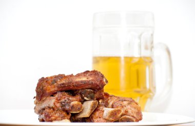 Bir sürahi bira ile beyaz bir plaka üzerinde sonraki kavrulmuş Domuz kaburga