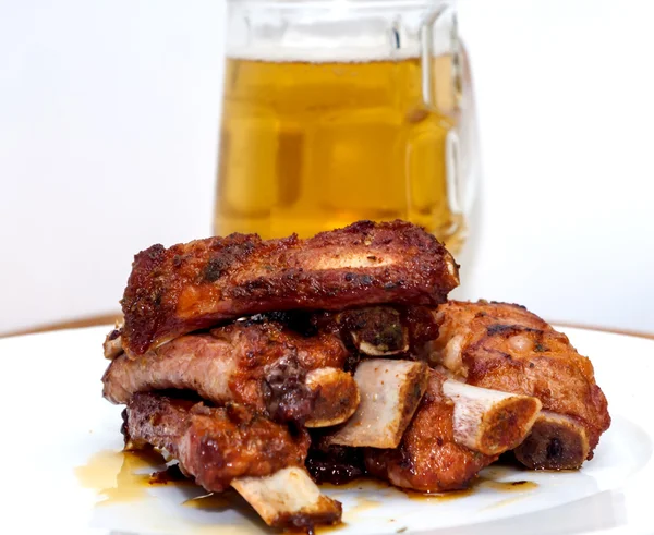 다음 맥주의 투 수와 흰 접시에 구운된 돼지 갈비 — 스톡 사진