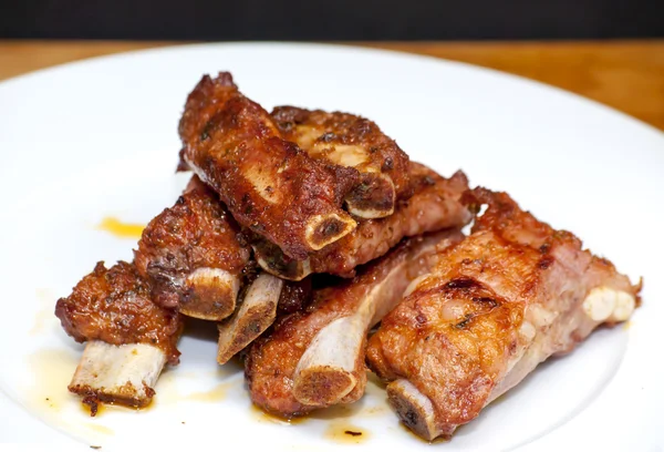 Costillas de cerdo asadas en un plato blanco — Foto de Stock