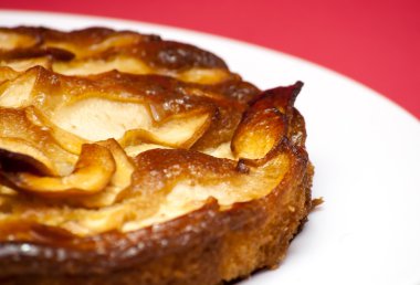 Elmalı turta kırmızı arka plan ile beyaz bir plaka üzerinde