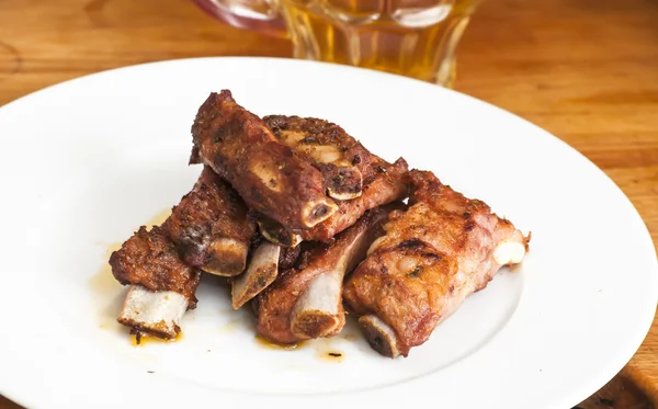 Costillas de cerdo asadas en un plato blanco — Foto de Stock