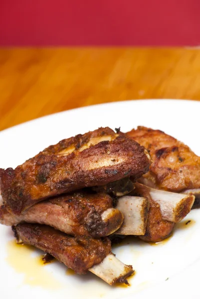 Côtes de porc rôties sur une assiette blanche — Photo