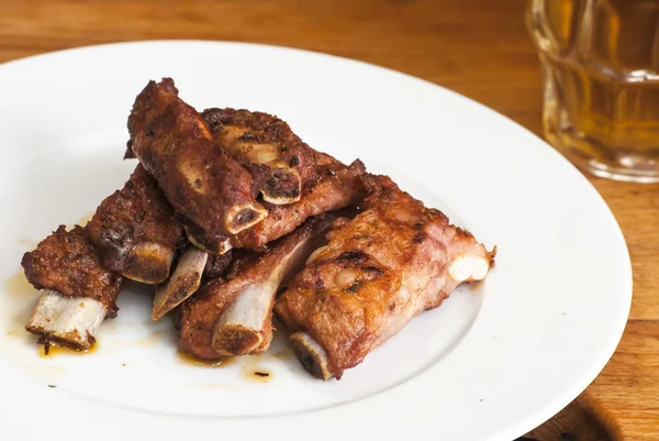 Roasted pork ribs on a white plate — Stock Photo, Image