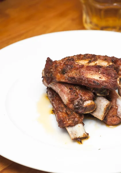 Costillas de cerdo asadas en un plato blanco — Foto de Stock