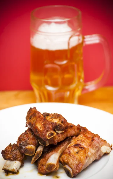 다음 맥주의 투 수와 흰 접시에 구운된 돼지 갈비 — 스톡 사진
