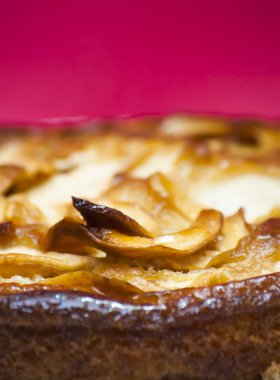 Elmalı turta kırmızı arka plan ile beyaz bir plaka üzerinde