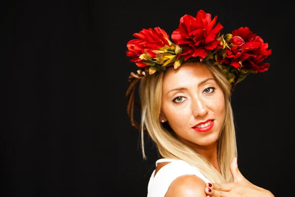 Mooie vrouw met een witte robe en krans van bloemen — Stockfoto