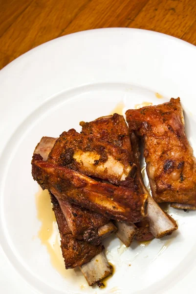 Roasted pork ribs on a white plate — Stock Photo, Image