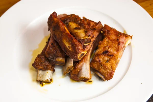 Roasted pork ribs on a white plate — Stock Photo, Image