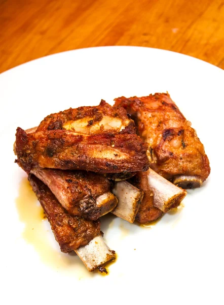 Roasted pork ribs on a white plate — Stock Photo, Image