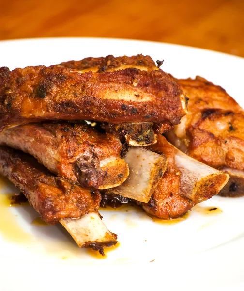 Roasted pork ribs on a white plate — Stock Photo, Image