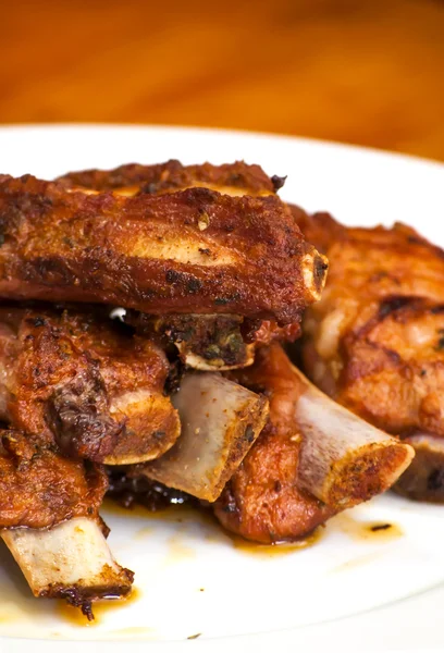 Costillas de cerdo asadas en un plato blanco — Foto de Stock