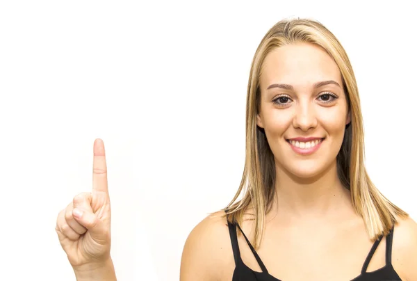 Schöne junge Frau zeigt mit dem Finger nach oben — Stockfoto