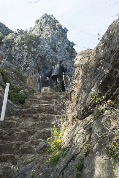 Dos montañistas suben una escalera de piedra en las montañas — Foto de Stock