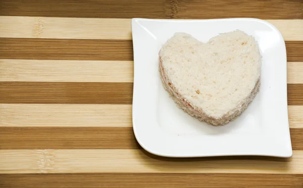 Sandwich de amor sobre fondo de madera — Foto de Stock