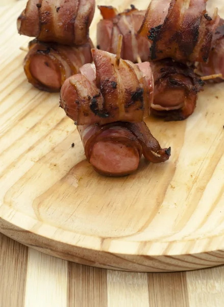 Salsichas fritas enroladas em bacon — Fotografia de Stock