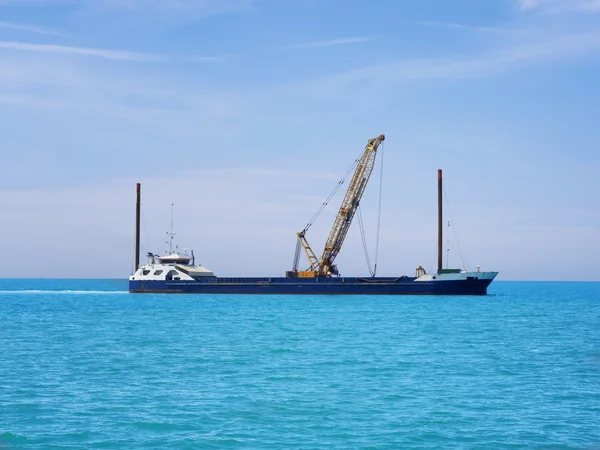 Guindaste sobre esteiras rolantes em barco e oceano — Fotografia de Stock