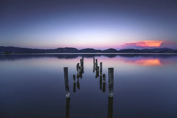 木製の桟橋や桟橋は青い湖の夕日と空スペース リフレに残ります — ストック写真