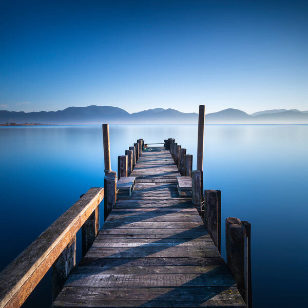 Wooden pier or jetty and lake at sunrise. Torre del Lago Puccini, Versilia, Massaciuccoli lake, Tuscany, Italy, Europe