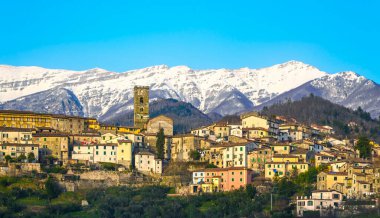 Coreglia Antelminelli, beautiful village and snowy Apennines mountains on background in winter. Garfagnana, Tuscany, Italy Europe clipart