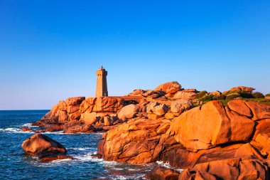 Ploumanach lighthouse sunset in pink granite coast, Brittany, Fr clipart