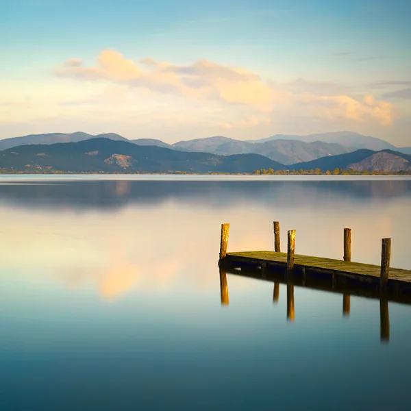 Ahşap iskele veya iskelesi ve mavi göl günbatımı ve gökyüzü reflectio — Stok fotoğraf