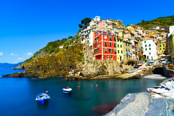 Riomaggiore pueblo, rocas y el mar al atardecer. Cinque Terre, Ligu — Foto de Stock
