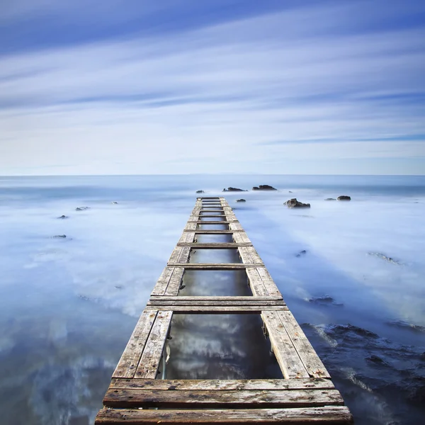 Träbrygga eller brygga på en blå havet på morgonen. Långa kraven — Stockfoto