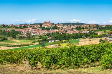 Monferrato, Piedmont 'taki Casorzo tepesinin panoramik manzarası. Ortaçağ kasabası, önemli kilisesiyle bölgenin üzüm bağlarıyla çevrilidir..
