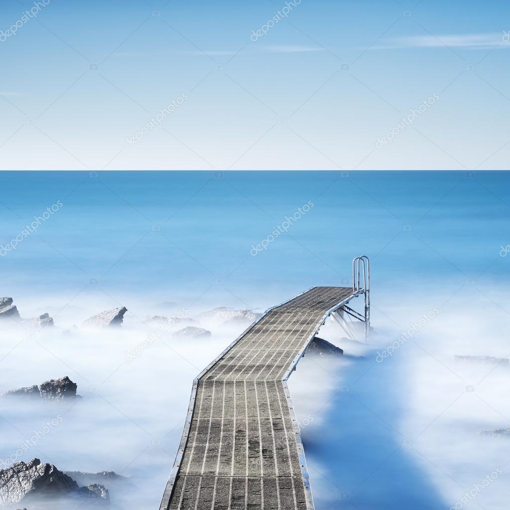 Pier or jetty on a blue ocean in the morning. Long Exposure