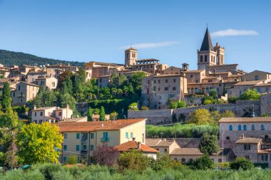 İtalya 'nın Umbria bölgesindeki tarihi Spello köyünün ufuk çizgisi manzarası. Eski taş binalar ve kilise çan kuleleri