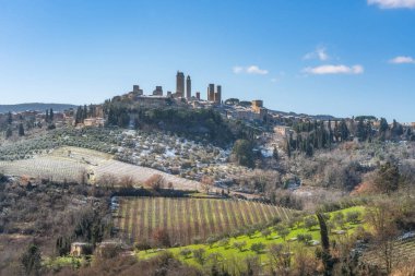 San Gimignano ortaçağ kasabasının kış manzarası hafif karla kaplıydı. İtalya 'nın Siena bölgesindeki Toskana kırsalında karlı üzüm bağları ve zeytin ağaçları