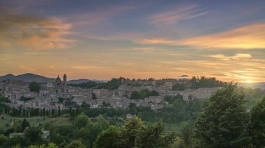 Gün batımında Rönesans şehri Urbino 'nun panoramik manzarası. İtalya 'nın Marche bölgesinde, renkli bir gökyüzünün altında Ducal Palace ile birlikte tarihi gökyüzü.