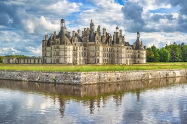 Rönesans Şatosu de Chambord 'un manzarası hendeğe yansıdı. Fransa 'nın Loire Vadisi' nde süslü kuleleri ve bahçeleri olan ünlü kraliyet kalesi.