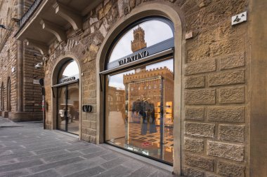 FLORENCE, TUSCANY - İTALYA 21 HAZİRAN 2026 Valentino Lüks butiği Piazza della Signoria 'da. Palazzo Vecchio ve kulesi cam pencerelere yansıyor.