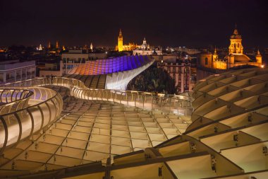SEVILLE, ANDALUSIA - SPAIN 14 EYLÜL 2011 Seville gökyüzünün modern Metropol Şemsiyesinden panoramik gece görüşü. Giralda Kulesi ve Katedral ahşap binadan görünüyor.