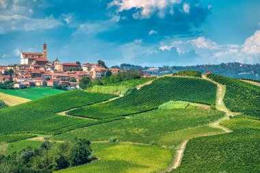 Grana Monferrato 'nun tarihi köyünün panoramik manzarası yuvarlanan tepeler ve yemyeşil üzüm bağlarıyla çevrili bulutlu mavi gökyüzü, Asti, Piedmont, İtalya