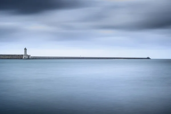 Livorno port lighthouse, breakwater and soft water under cloudy — Stock Photo, Image