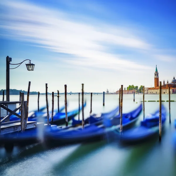 Venecia, góndolas o góndolas al atardecer y la iglesia al fondo . —  Fotos de Stock