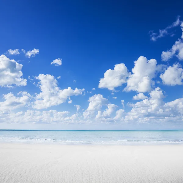 Strand van wit zand, tropische oceaan en blauwe hemel — Stockfoto