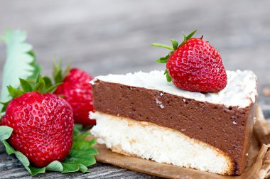 Piece of chocolate cake of two layers with fresh strawberries.