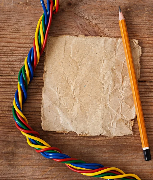 Papier und Elektrokabel auf dem alten Holzgrund. — Stockfoto