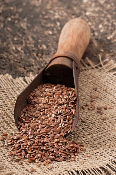 Old measuring scoop with flax seeds — Stock Photo, Image