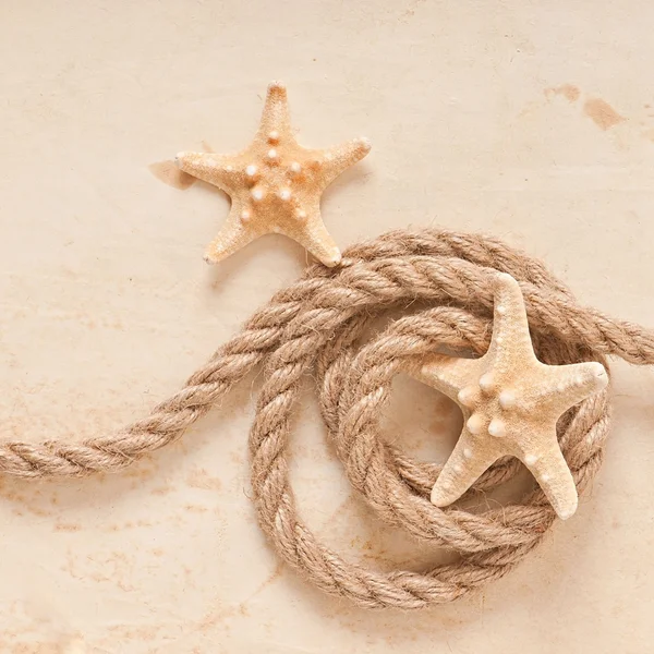 Sjöstjärnor och rep på gamla papper bakgrund — Stockfoto