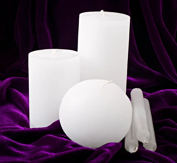 Decorative candles against the dark fabric — Stock Photo, Image