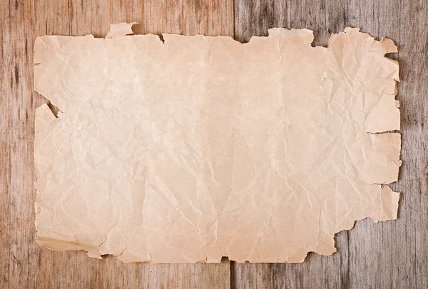 Старая бумага на старом деревянном фоне — стоковое фото