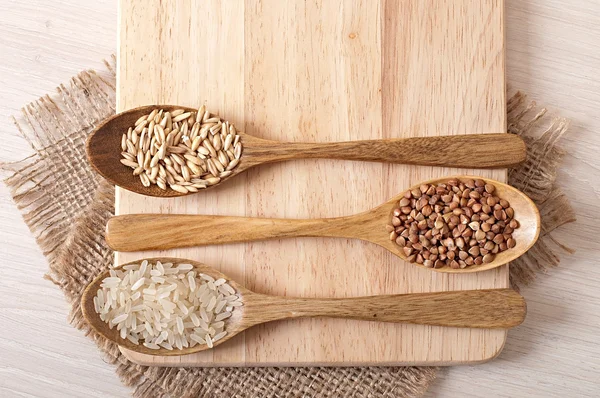 Cucchiai di legno e grano saraceno, riso e avena — Foto Stock