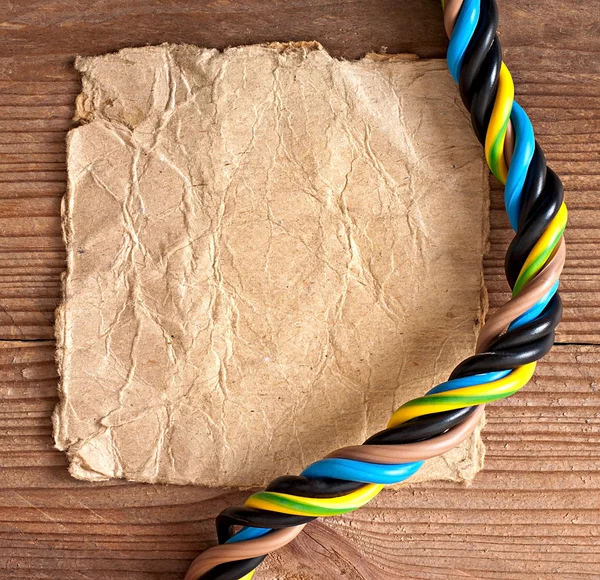 Papír és az elektromos kábel a régi, fából készült háttér — Stock Fotó