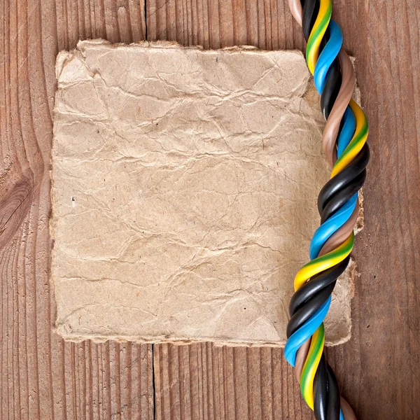 Papier i kabel elektryczny na stare drewniane tła — Zdjęcie stockowe