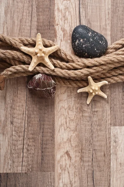 Rope, starfish, sea stones on the old wooden background — Stock Photo, Image